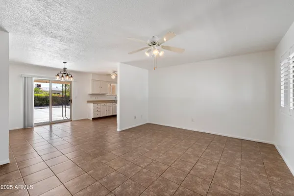 an empty room with windows and ceiling fan