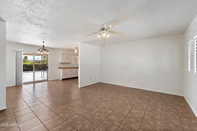 an empty room with windows and ceiling fan