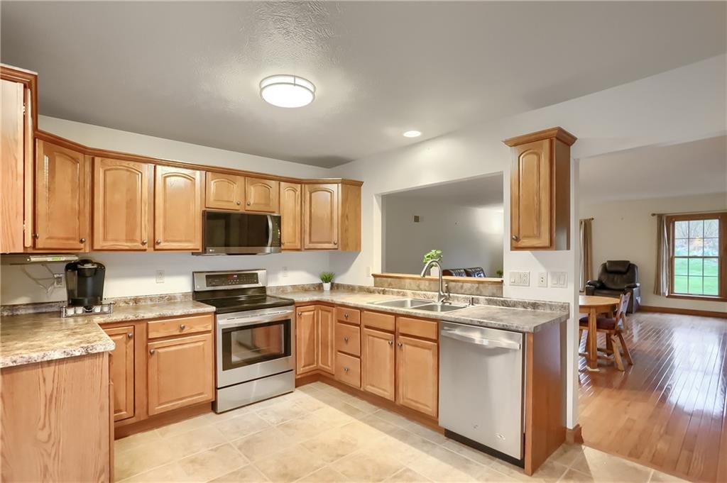 119 South Butler Street Saxonburg, PA 16056 - Photo 10 of 39 a kitchen with a sink stove and wooden cabinets