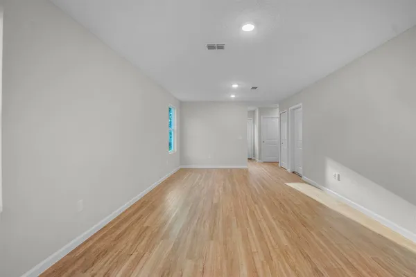 a view of an empty room and wooden floor