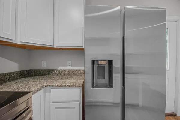 a kitchen with granite countertop cabinets stainless steel appliances and a counter space