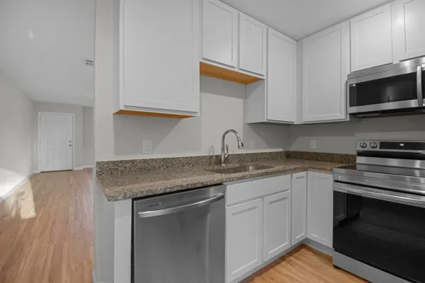 a kitchen with granite countertop a sink and a stove