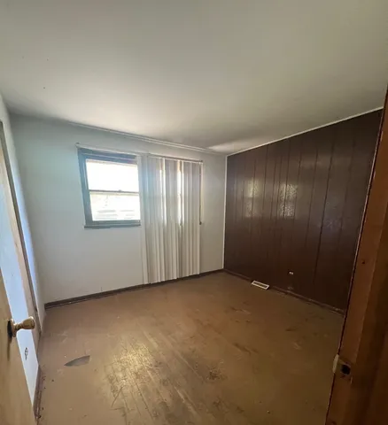 a view of an empty room with windows and closet