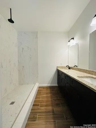 a bathroom with a double vanity sink a mirror and shower