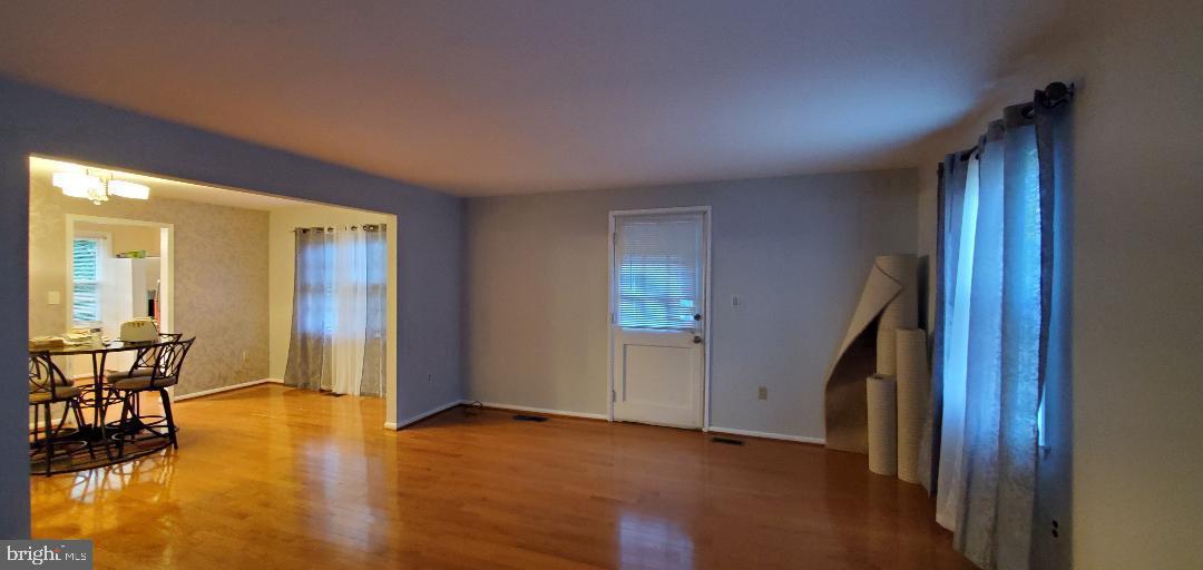 8512 Imperial Drive, Unit 1H Laurel, MD 20708 - Photo 3 of 14 an empty room with wooden floor and furniture