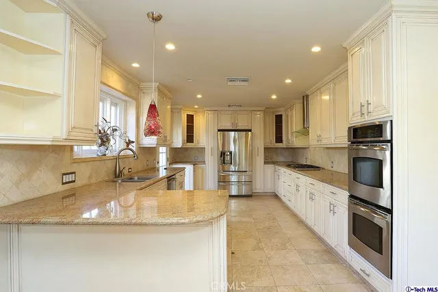 a large kitchen with stainless steel appliances granite countertop a large counter top and a stove