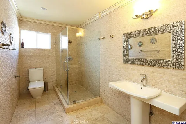 a bathroom with a shower sink mirror and toilet