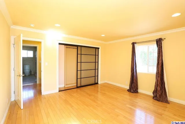 a view of empty room with wooden floor