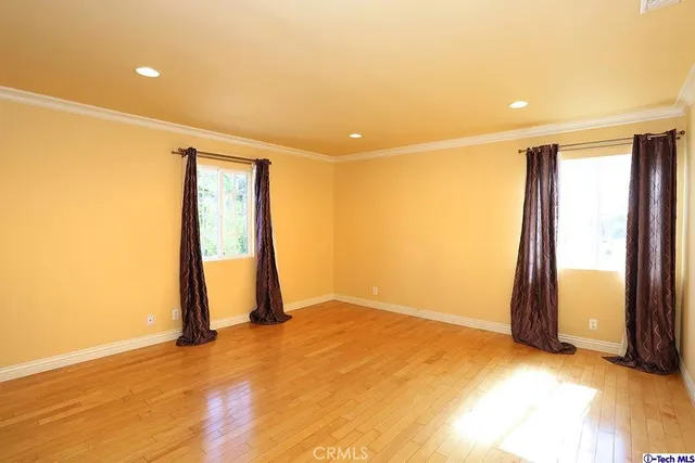 an empty room with wooden floor and a window