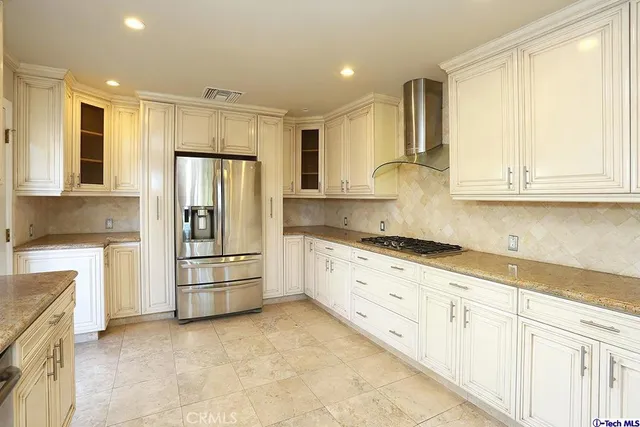 a kitchen with granite countertop white cabinets and stainless steel appliances