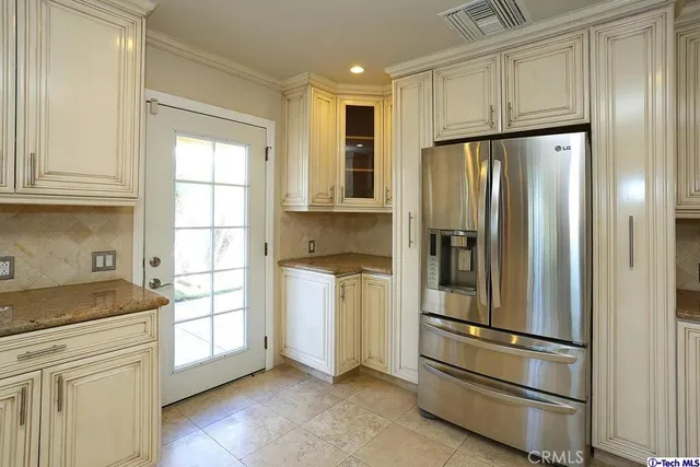 a kitchen with stainless steel appliances granite countertop a refrigerator and a stove top oven