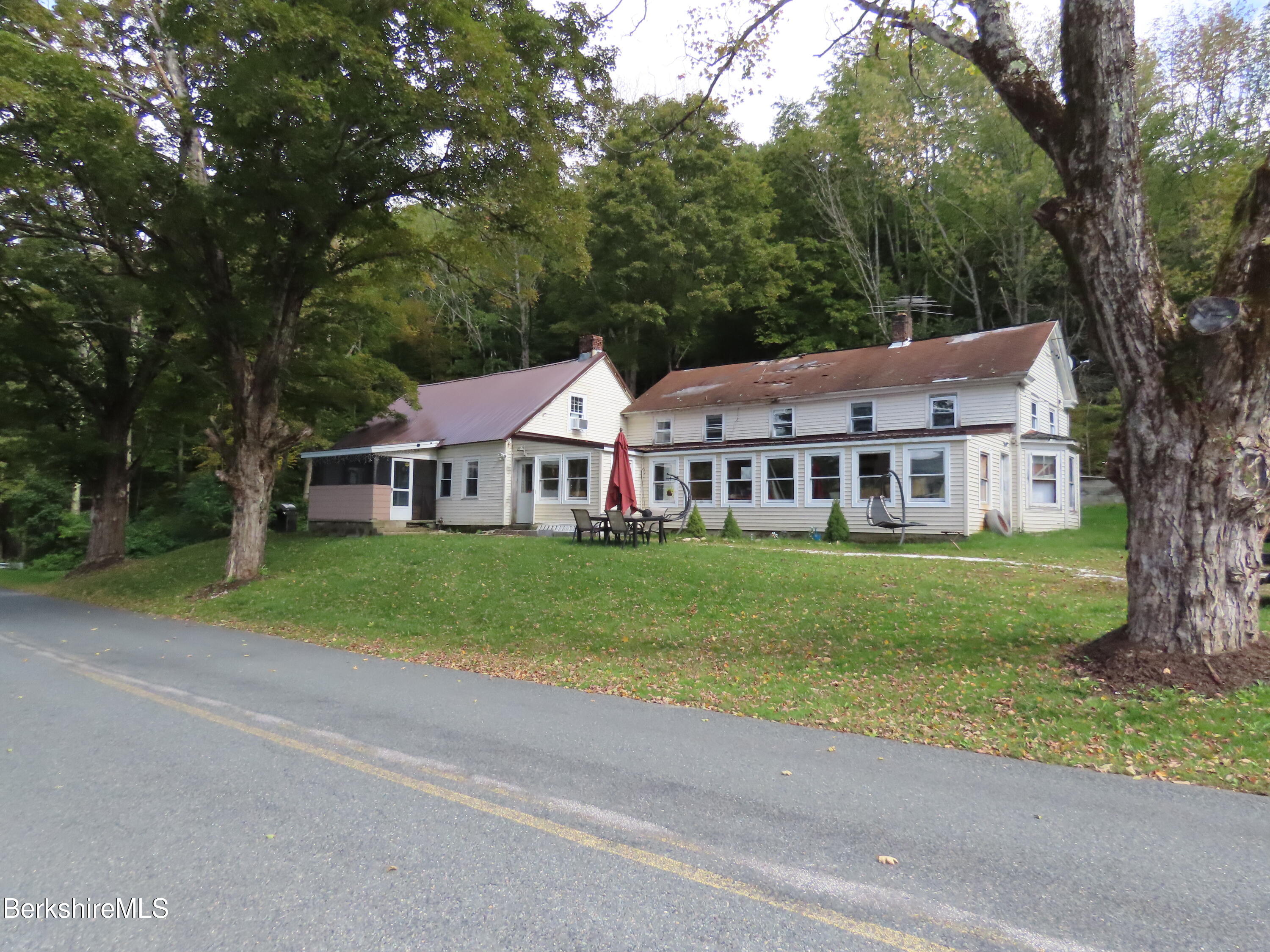 660 E Road Stamford, VT 05352 - Photo 2 of 41 a view of a white house with a big yard plants and large trees