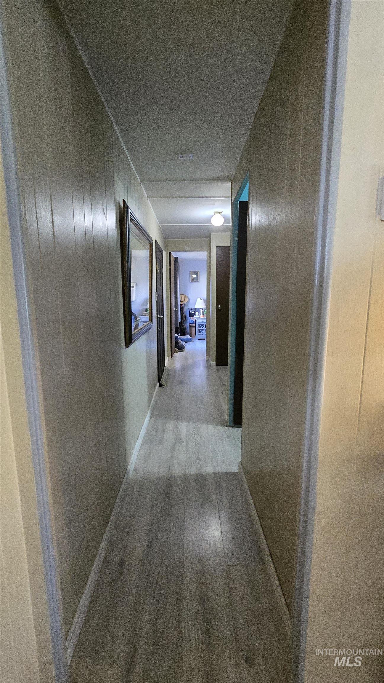 798 Dolson Lane Eagle, ID 83616 - Photo 12 of 33 Hall with wood walls and light wood-style floors