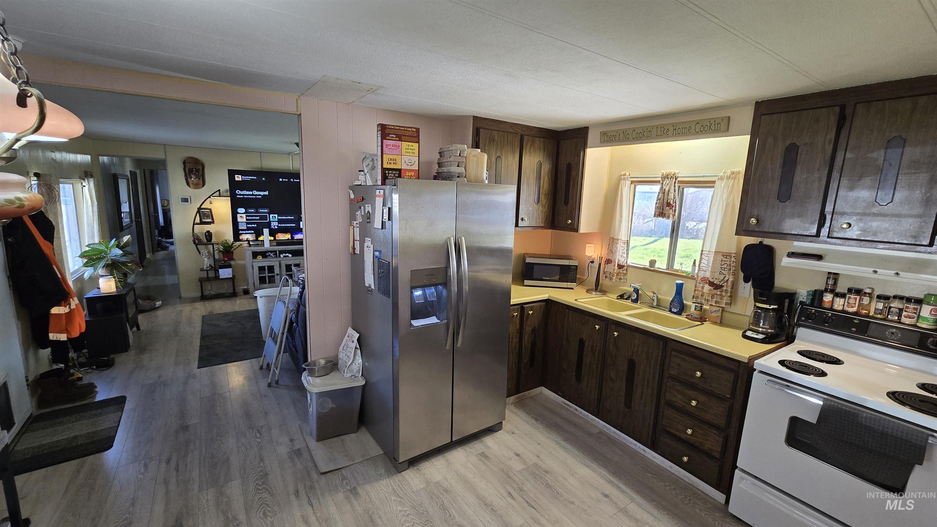 798 Dolson Lane Eagle, ID 83616 - Photo 20 of 33 Kitchen featuring dark wood finish cabinets, stainless steel appliances, light countertops, and light wood finished floors