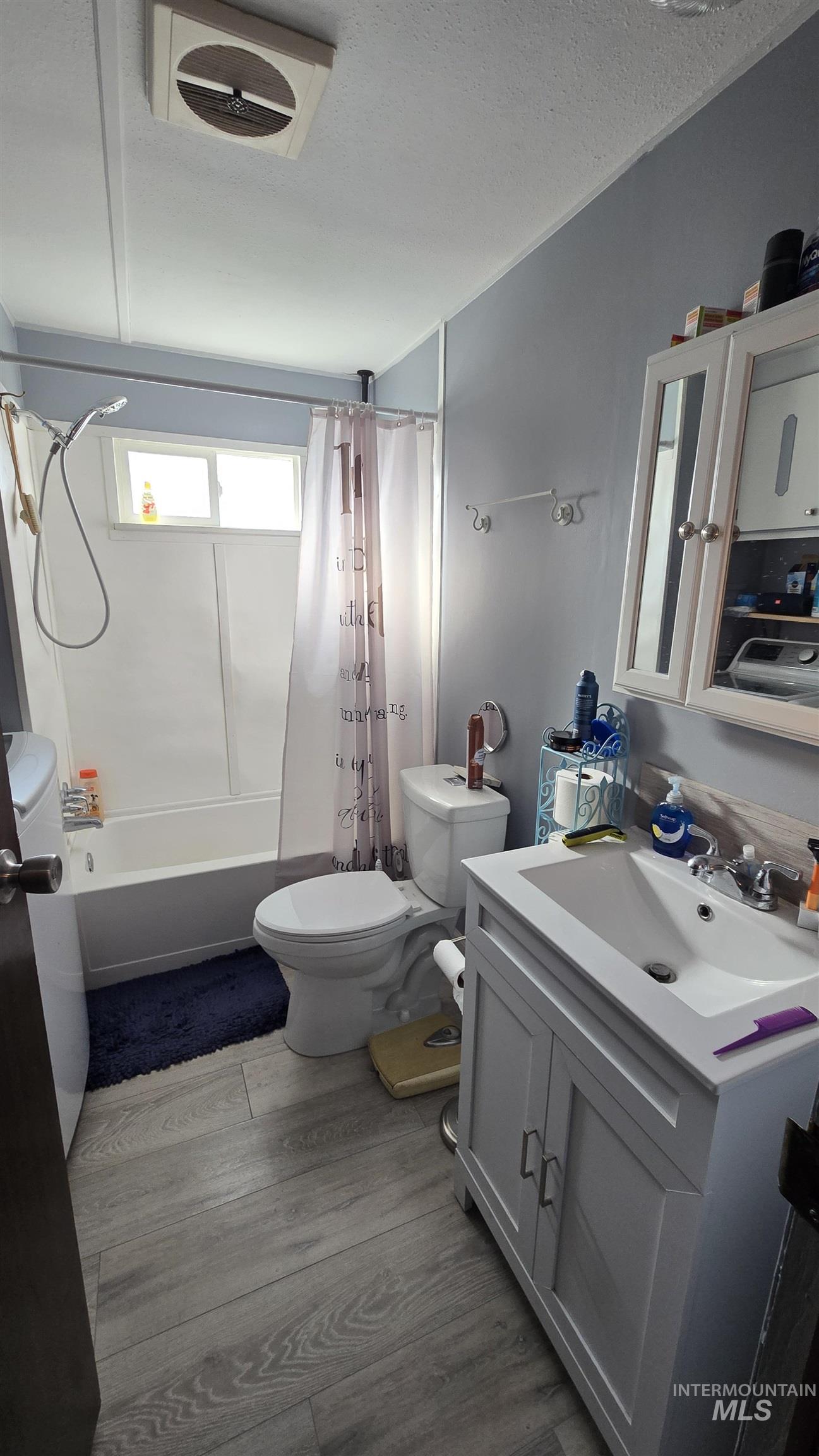 798 Dolson Lane Eagle, ID 83616 - Photo 7 of 33 Bathroom featuring vanity, shower / bath combination with curtain, a textured ceiling, and dark wood-style floors
