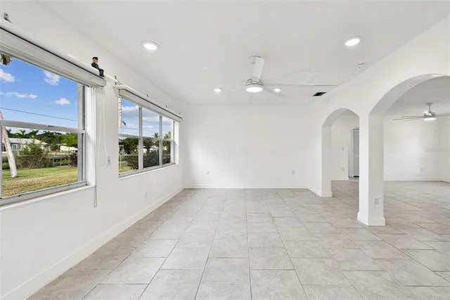 a view of an empty room with glass door and chandelier