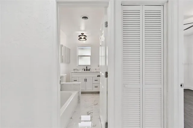 a bathroom with a bathtub sink vanity and mirror