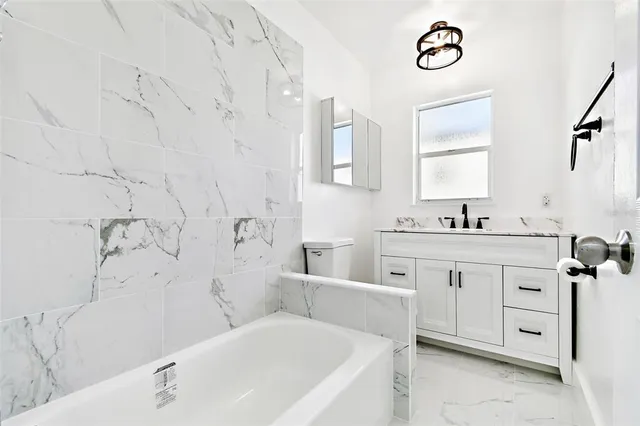 a bathroom with a tub sink and mirror
