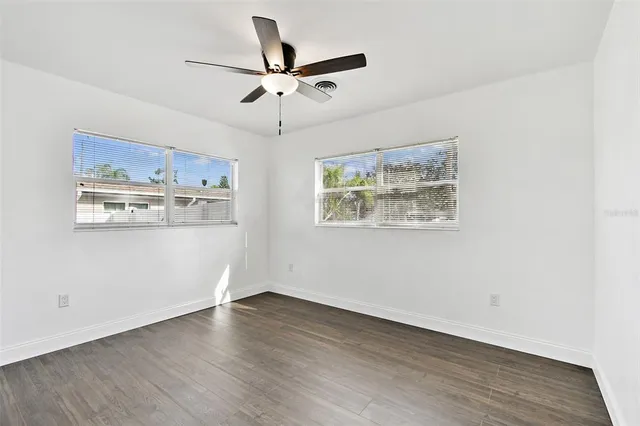 a view of a room with wooden floor and a ceiling fan