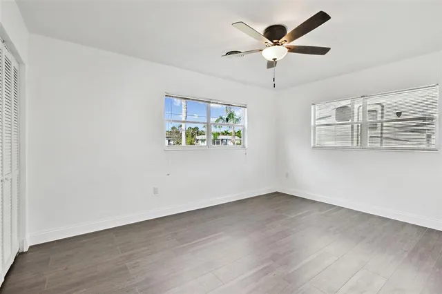 an empty room with window and ceiling fan