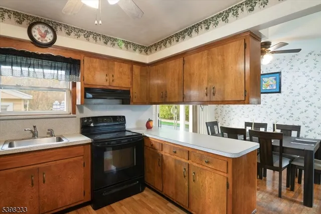 a kitchen with stainless steel appliances granite countertop a stove a sink a refrigerator and wooden cabinets