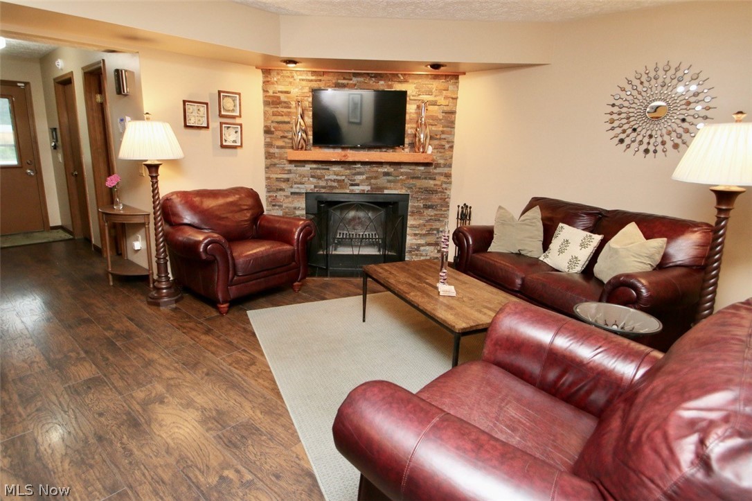 95 Park Road Painesville, OH 44077 - Photo 2 of 27 Family room with wood-style floors, a stone wood burning fireplace. Open to Kitchen could be used as hearth room