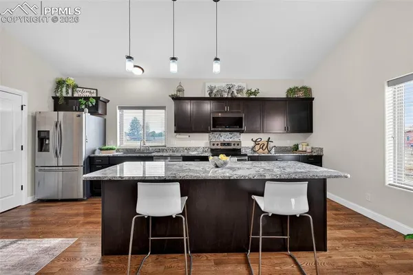 a kitchen with stainless steel appliances granite countertop a sink and a refrigerator
