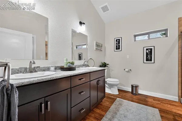 a bathroom with a granite countertop toilet sink and a mirror