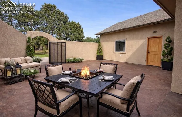 a backyard of a house with fire pit table and chairs