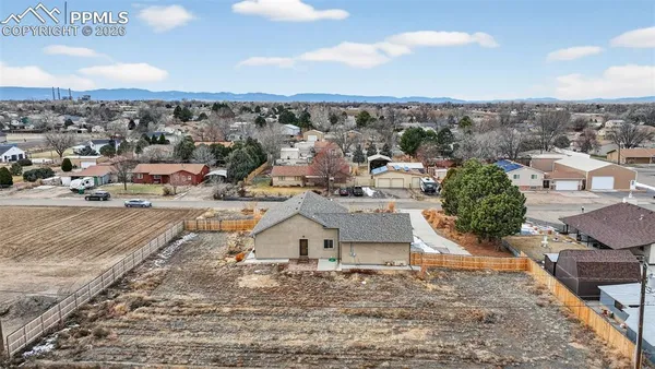 an aerial view of a house with a yard and sitting area