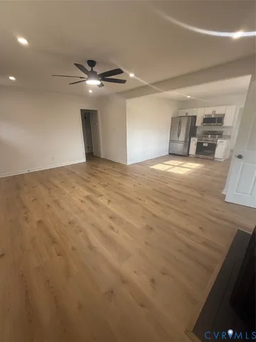 a view of empty room with wooden floor