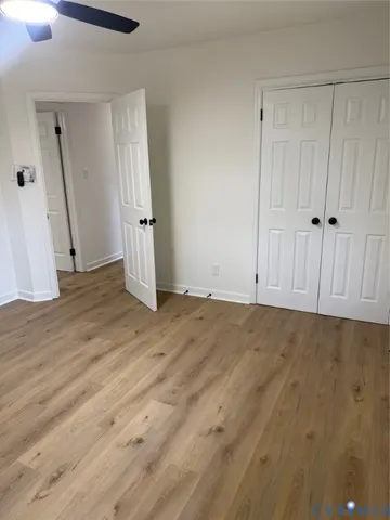 an empty room with wooden floor and entrance