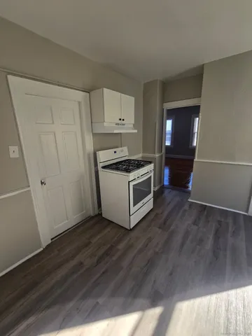 a kitchen with cabinets and wooden floor