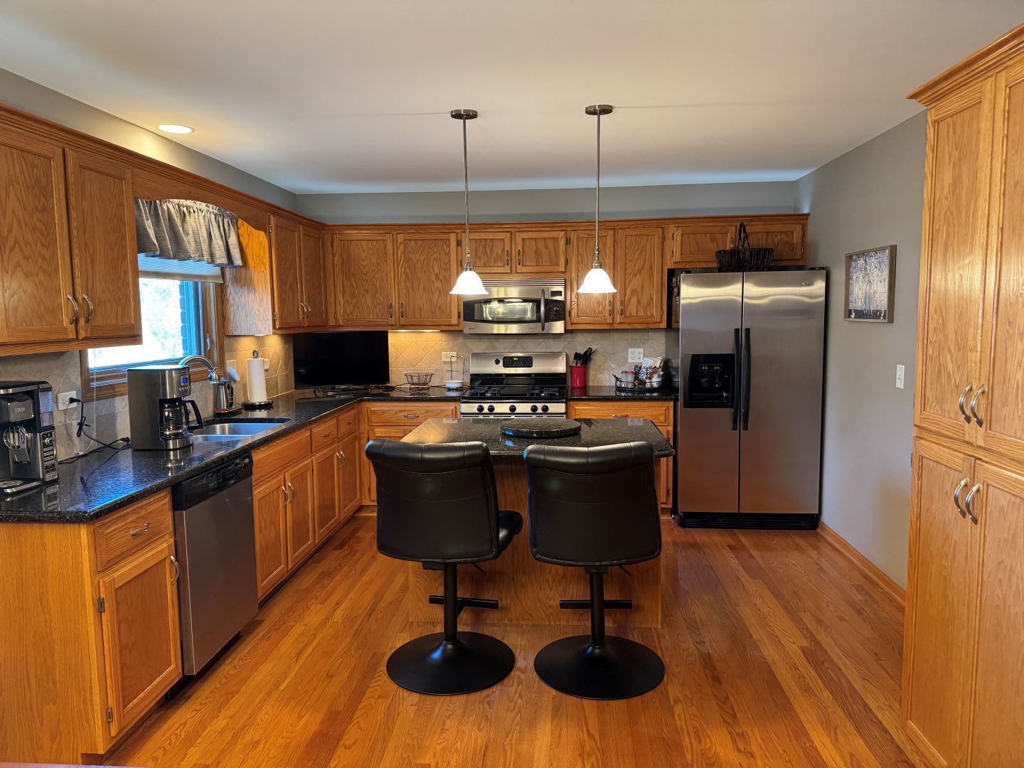 1397 O'Connell Circle New Lenox, IL 60451 - Photo 6 of 23 a kitchen with stainless steel appliances granite countertop a refrigerator a sink dishwasher a stove and a dining table with wooden floor