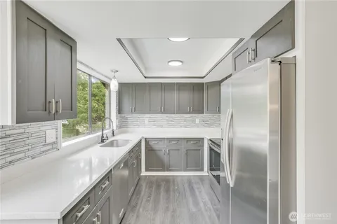 a kitchen with a sink refrigerator and window