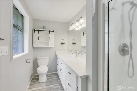 a spacious bathroom with a double vanity sink a toilet and a mirror