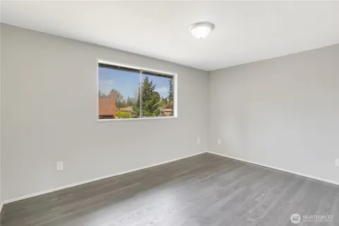 an empty room with wooden floor and window