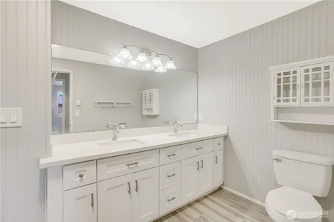 a bathroom with a double vanity sink and a toilet