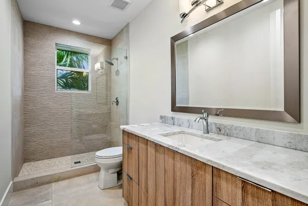 a bathroom with a granite countertop sink toilet and shower
