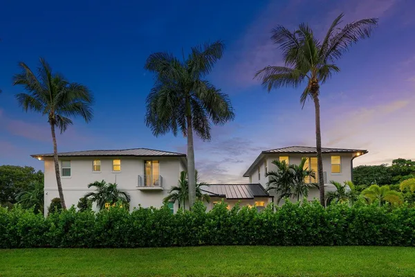 a palm tree sitting in front of a house with a palm tree