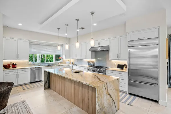 a kitchen with a sink refrigerator and cabinets