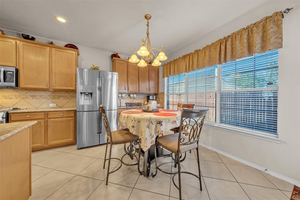 2244 Condor Street Grand Prairie, TX 75052 - Photo 14 of 37 a dining room filled a chandelier and kitchen view