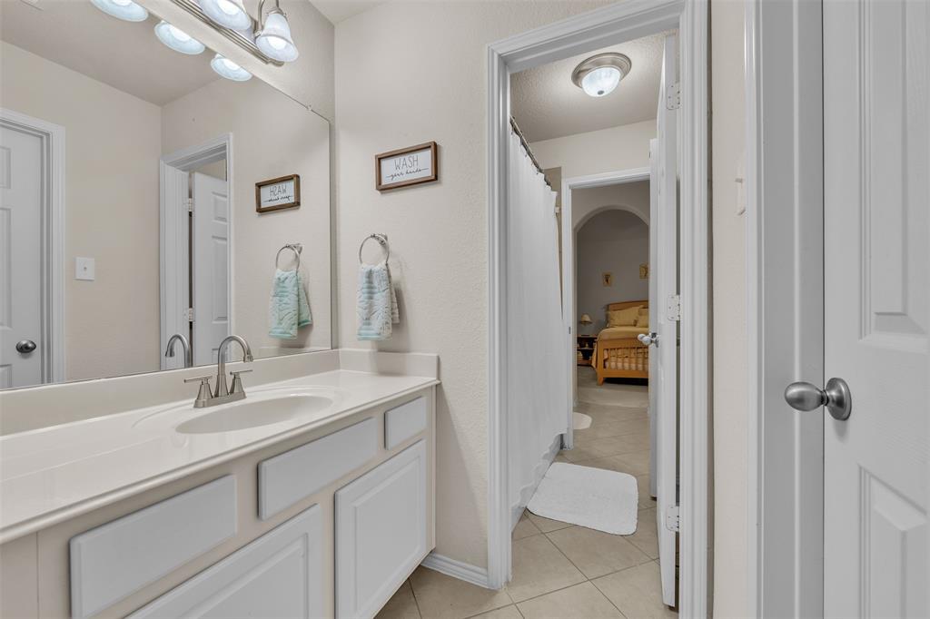 2244 Condor Street Grand Prairie, TX 75052 - Photo 28 of 37 a en suite bathroom with a sink double vanity and a mirror