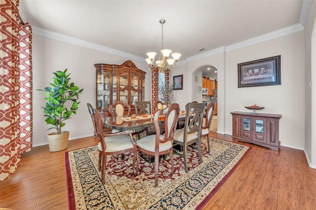 2244 Condor Street Grand Prairie, TX 75052 - Photo 6 of 37 a view of a dining room with furniture a chandelier and wooden floor