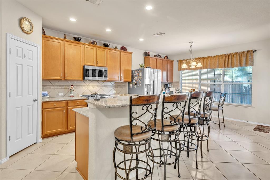 2244 Condor Street Grand Prairie, TX 75052 - Photo 8 of 37 a kitchen with stainless steel appliances granite countertop a stove a sink a microwave and a refrigerator