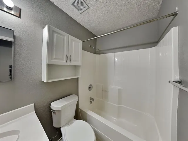 a white toilet sitting next to a bath tub