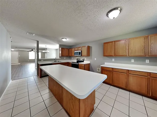 a large kitchen with stainless steel appliances lots of counter top space