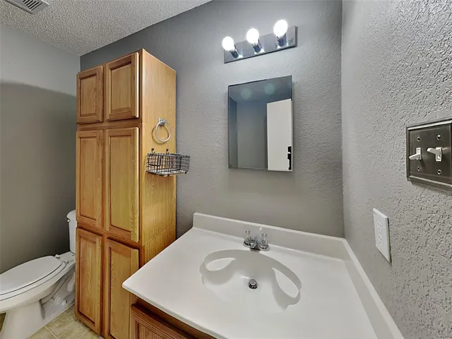 a bathroom with a sink a toilet and mirror
