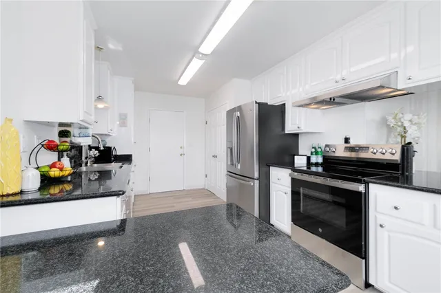 a kitchen with stainless steel appliances a stove a refrigerator and a cabinets