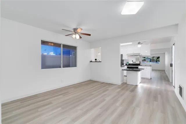 a view of kitchen with refrigerator and white cabinets